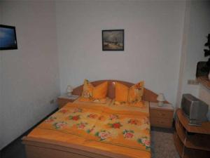 ヴァーネミュンデにあるIwan Ferienwohnungen Objekt 26001のベッドルーム1室(大型ベッド1台、オレンジ色の枕付)