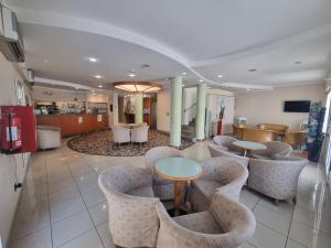 a lobby with chairs and tables and a kitchen at Hotel Marina in Riccione