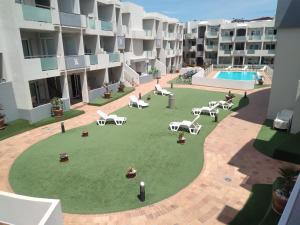 einen Innenhof mit einem Apartment mit Liegestühlen und einem Pool in der Unterkunft GARDEN 128 in Corralejo