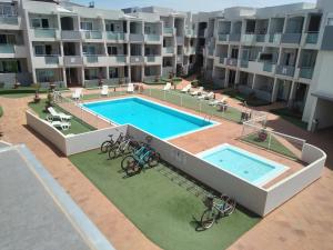 an apartment building with a swimming pool and bikes in front of it at GARDEN 128 in Corralejo
