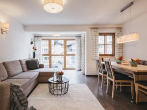 een woonkamer en een keuken met een bank en een tafel bij Residence Kristall by VAYA in Saalbach Hinterglemm