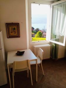 mesa y sillas en una habitación con ventana en Nora Casa Vacanze, en Dervio