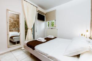 a white bedroom with a bed and a window at Villa Archontiki I - Private Pool in Vryses +36 photos
