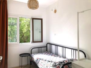 a bedroom with a bed and a mirror and two windows at Naked House Sardinia in Bari Sardo