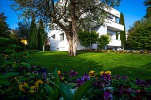 a tree in the middle of a yard with flowers at Giardino Segreto in Peschiera del Garda