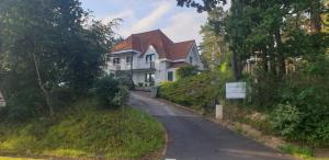 une maison sur une colline avec une route dans l'établissement APPARTEMENT LES PINS PENCHES Hardelot plage, à Neufchâtel-Hardelot