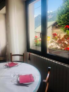 a table with red napkins and a table with a window at Auberge du Glandon in Saint-Colomban-des-Villards