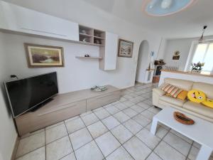 a living room with a couch and a flat screen tv at Casa Gabry in Valbrona