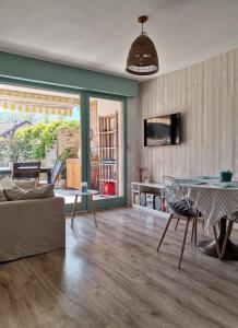 a living room with a couch and a table at ** Nouveau ** Le Jardin De La Plage - Appartement avec extérieur in Saint-Jorioz