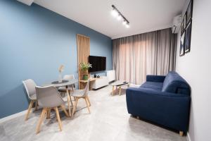 a living room with a blue couch and a table at Apartament Ogrody Centrum in Bielsko-Biała