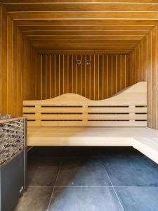un grand banc en bois dans un sauna dans l'établissement Camping 3 étoiles Les Fougères, à Rivedoux-Plage