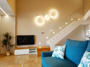 a living room with a blue couch and a tv at Duplex Premium Peñiscola Playa Orangecosta in Peñíscola