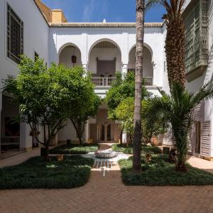 a courtyard of a building with palm trees at Riad Talaa12 in Marrakesh