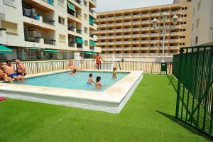 a group of people in a swimming pool in a building at Duplex Premium Peñiscola Playa Orangecosta in Peñíscola