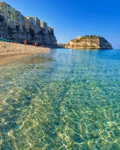 uma praia com águas cristalinas e edifícios em Dreams Tropea Mare "Parking Private" em Tropea
