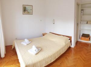 a bedroom with a bed with two white towels on it at Apartments Lucija in Stari Grad