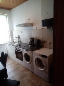una cocina con lavadora y secadora. en Hotel Klappenburg en Hannover