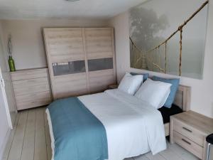 a bedroom with a large white bed and a wooden cabinet at Ons Strandhuis in IJmuiden