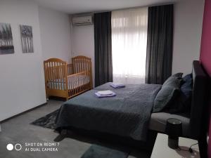 a bedroom with a bed and a crib and a television at Markaz Apartman Bihać 2 in Bihać