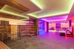 Großes Zimmer mit violetten Lichtern an der Decke in der Unterkunft FOR MOMENTS Apartments & Spa in Roßhaupten