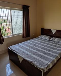 a bed in a bedroom with a large window at Ashiyana Rest House in Deoghar