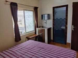 ein Schlafzimmer mit einem Bett und ein Badezimmer mit einer Dusche in der Unterkunft Ashiyana Rest House in Deoghar