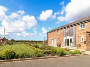 an image of a brick house with a yard at The Old Stables in Preston