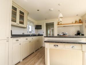 a kitchen with white cabinets and a counter top at The Old Stables in Preston