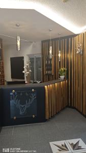 a lobby with a reception desk with a television and plants at Hotel Zum Hirsch in Römhild