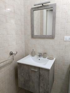 uma casa de banho com um lavatório e um espelho em Il filo di Iago em Savona