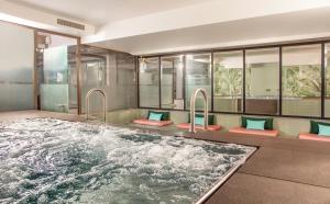 eine Whirlpool-Badewanne in einem Zimmer mit Fenstern in der Unterkunft Hotel Bristol in Genf
