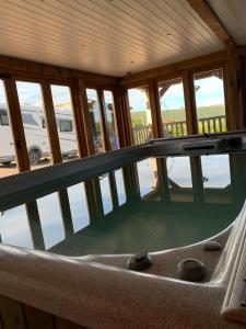 a bath tub in a room with windows at Ty Nofio, Coity Bach in Brecon