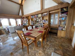 a dining room with a table and chairs and bookshelves at Ty Nofio, Coity Bach in Brecon