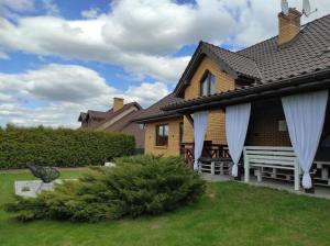 a yellow house with white curtains on a yard at Norwida 28 - 300m od plaży in Olecko