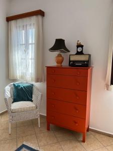 a dresser with a lamp on top of it next to a chair at Kaya Apart & Pansiyon in Bodrum City