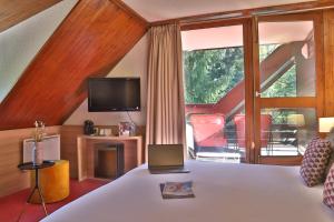 een slaapkamer met een bed en een tv bij SOWELL HOTELS Mont Blanc et SPA in Saint-Gervais-les-Bains