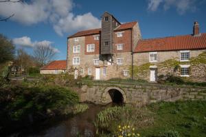 an old stone building with a bridge and a building at Vivers Mill in Pickering
