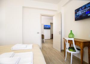 ein Schlafzimmer mit Bett, Schreibtisch und Fernseher in der Unterkunft CENTRAL STATION APARTMENTS - Fanale Rentals in Palermo