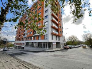 a tall building on a street with a parking lot at Nataly Homes in Veliko Tŭrnovo