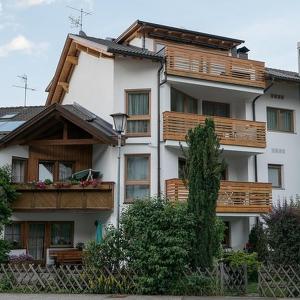 un gran edificio blanco con balcones de madera. en Ciasa Irene App Mansarde, en La Villa