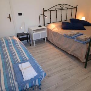 1 dormitorio con 2 camas y suelo de madera en Blu Salento, en Squinzano