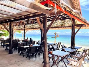 a restaurant on the beach with tables and chairs at Phi Phi Relax Beach Resort in Phi Phi Islands