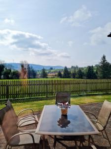 a table and chairs on a patio with a fence at Yellow Heights Country House in Tinahely
