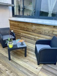 dwa krzesła i stolik kawowy na patio w obiekcie Les Gîtes de Claire w mieście Honfleur