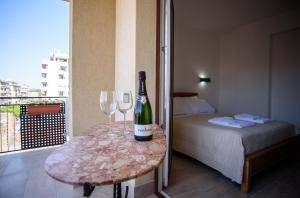 Zimmer mit einem Tisch mit einer Flasche Wein und zwei Gläsern in der Unterkunft CENTRAL STATION APARTMENTS - Fanale Rentals in Palermo