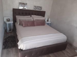 una camera con un grande letto con testiera in legno di Casa Daniela a San Felice Circeo