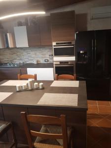 a kitchen with a table with chairs and a black refrigerator at Casa Daniela in San Felice Circeo