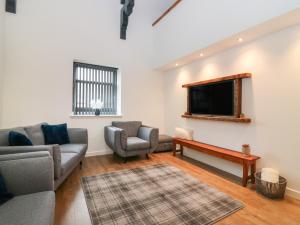 uma sala de estar com 2 sofás e uma televisão de ecrã plano em The Reception Room at The Institute Executive Apartments em Keith