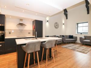 a kitchen and living room with a counter and chairs at The Reception Room at The Institute Executive Apartments in Keith