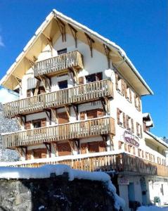 un edificio con balcones de madera en un lateral en Auberge du Glandon, en Saint-Colomban-des-Villards
